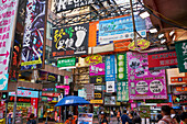 Advertising signs on a busy street in the popular shopping area of Mong Kok (Mongkok), Kowloon, Hong Kong, China, Asia