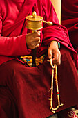 Tibetan Buddhist monk with prayer wheel and beads at Losar (Tibetan New Year) in the Dalai Lama Temple, McLeod Ganj, Dharamsala, Himachal Pradesh, India, Asia