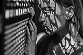 Caucasian woman with freckles leaning on window