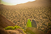 Boys sitting on rock admiring desert landscape