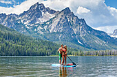 Caucasian couple on paddleboard in lake
