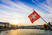 Swiss flag at sunset, River Rhone, Geneva, Switzerland, Europe