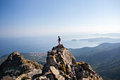 Hiker admires the sea from the top of Monte Capanne, Elba Island, Livorno Province, Tuscany, Italy, Europe