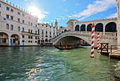 A gondolier rowing under Rialto Bridge in Venice, UNESCO World Heritage Site, Veneto, Italy, Europe