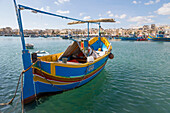 Traditional brightly painted fishing boat in the harbour at Marsaxlokk, Malta, Mediterranean, Europe