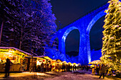 Snowy Christmas market under a railway viaduct, illuminated, Ravennaschlucht, Höllental near Freiburg im Breisgau, Black Forest, Baden-Württemberg, Germany