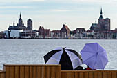 Blick auf Altstadt mit Menschen mit Regenschirmen davor. Stralsund, Ostseeküste, Mecklenburg-Vorpommern, Deutschland