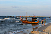 People and small wooden fishing boat on the beach of Ahlbeck, Usedom, Ostseeküste, Mecklenburg-Western Pomerania, Germany