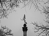 View of the Friedensengel through the snowy trees, Munich, Upper Bavaria, Germany