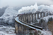 A wintery scene of the Glenfinnan Railway Viaduct with steam locomotive, Highlands, Scotland, United Kingdom, Europe