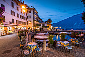 View of illuminated promenade at the port of Limone at dusk, Lake Garda, Lombardy, Italian Lakes, Italy, Europe