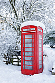 Traditional British red telephone box covered in winter snow, Snowshill, Cotswolds, Gloucestershire, England, United Kingdom, Europe
