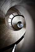 Looking up through a masonry spiral staircase.