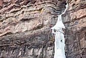 A man and woman ice climbing up a frozen waterfall called Cascade Falls in a basin right above the historic downtown of Ouray, Colorado, USA