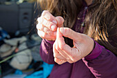 Close up of female anglers hands as she prepares her line for fishing in Colorado River, Silverthorne, Colorado, USA