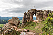 Woman jumping on top of Morro do Campestre in Urubici, Santa Catarina, Brazil