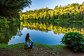 Woman sitting in front of Lago Negro lake in Gramado, Rio Grande do Sul, Brazil