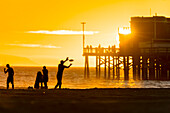 People playing plastic ring near Newport beach pier, Orange county, California, USA