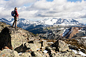 Female hiker looking at view of Garibaldi Provincial Park from top of Whistler Mountain, Whistler, British Columbia, Canada