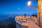 Woman on terrace looks towards Monte Cofano, Erice, province of Trapani, Sicily, Italy, Mediterranean, Europe