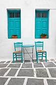 Typical Greek cafe table and chairs with shuttered windows, Pano Chora, Serifos, Cyclades, Aegean Sea, Greek Islands, Greece
