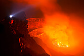 Man looking into crater at night, Mount Nyiragongo, Virunga National Park, Democratic Republic of the Congo