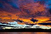 Cumulus clouds at sunset over lake in autumn, Upper Gnat Lake, British Columbia, Canada