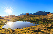 The sun reflects itself in a pond of Alpe Granda, Valtellina, Italy.