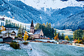 Autumn scenic outdoor, foliage and green hills with snowy trees, Funes Valley, Dolomites Alps, Trentino Alto Adige, Italy..