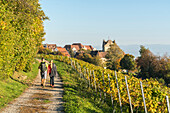 Couple walking on a pathway towards the town center. Meersburg, Baden-Württemberg, Germany.