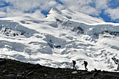 Trekkers with huge glacier behind, Grand Combin North Face, path to Panossiere hut, Switzerland,Swiss