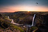 Paragliding over Haifoss waterfall at Fossa river at sunset, Southern Iceland, Iceland