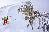 Two persons backcountry skiing standing in notch, Puezspitze, Natural Park Puez-Geisler, UNESCO world heritage site Dolomites, Dolomites, South Tyrol, Italy