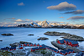 Fischerhäuser mit Küste und verschneiten Bergen, Lofoten, Nordland, Norwegen