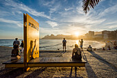 Photograph of sunset at Arpoador Beach with people, Rio de Janeiro, Brazil