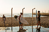 Men washing down surfboards near promenade on Golden Mile in Durban, South Africa