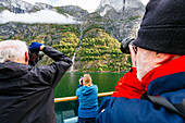 Ship passengers photographing waterfall in Naeroyfjord, Sogn og Fjordane, Norway