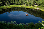 Tourist enjoying zip line over lagoon and cenotes of village near Cob, in Quintana Roo, Mexico