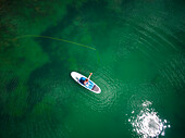 Aerial view of young male fly fishing from his paddle board on high alpine lake in Aspen, Colorado, USA