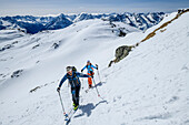 Man and woman backcountry-skiing ascending towards Rastkogel, Zillertal Alps in background, Rastkogel, Tuxer Alps, Tyrol, Austria