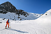 Woman backcountry-skiing ascending towards Cima Valon, Val di Rabbi, Ortler Group, Trentino, Italy