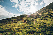 Wanderin beim Aufstieg im Abendlicht,E5, Alpenüberquerung, 2. Etappe, Lechtal, Holzgau, Tirol, Österreich, Kemptner Hütte zur Memminger Hütte