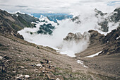 Climber on the descent over a sea of ??clouds, E5, Alpenüberquerung, 3rd stage, Seescharte,Inntal, Memminger Hütte to  Unterloch Alm, tyrol, austria, Alps