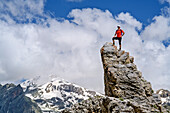Mann steht auf Felsturm, Passo della Cavalla, Val Maira, Cottische Alpen, Piemont, Italien