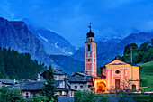 Beleuchtete Kirche und Häuser von Chialvetta mit Cottischen Alpen im Hintergrund, Chialvetta, Val Maira, Cottische Alpen, Piemont, Italien