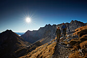 Two hiker coming from Lamsenspitze, Schafjoechl and Stallental valley in the back,  Eastern Karwendel Range, Tyrol, Austria