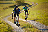 two young men on gravel bikel on a gravel road, Muensing, bavaria, germany