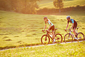 Young  woman an d young man on racebike, Muensing, bavaria, germany