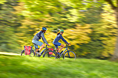 Young  woman on touring bike, young man on touring eBike on tour, Muensing, bavaria, germany
