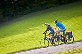 Young  woman on touring bike, young man on touring eBike on tour, Muensing, bavaria, germany